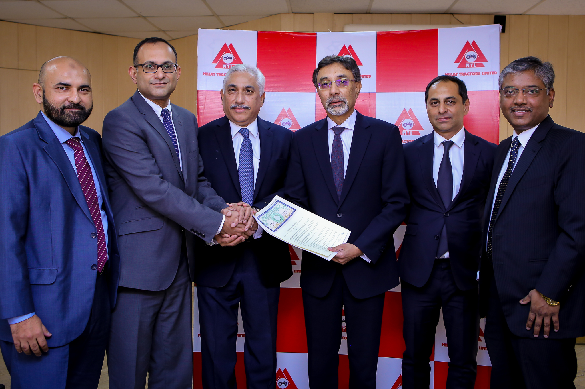 (From Left to Right) Mr. Ali Sarfraz Hussain - Chief Executive Officer, Karandaaz Pakistan, Mr. Syed Mohammad Irfan Aqueel - Chief Executive Officer, Millat Tractors Limited and Ariful Islam – Deputy CEO, Meezan Bank Limited at the signing ceremony, along with their teams.